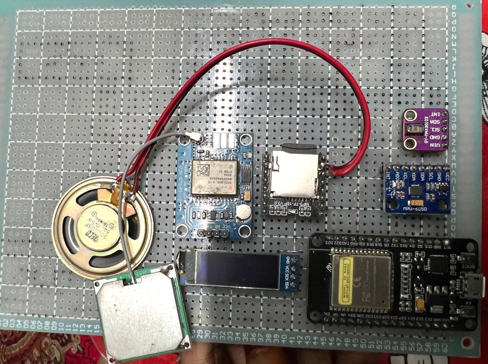 The prototype electronics laid out on perfboard: ESP32, OLED display, sensor modules, speaker and wiring.