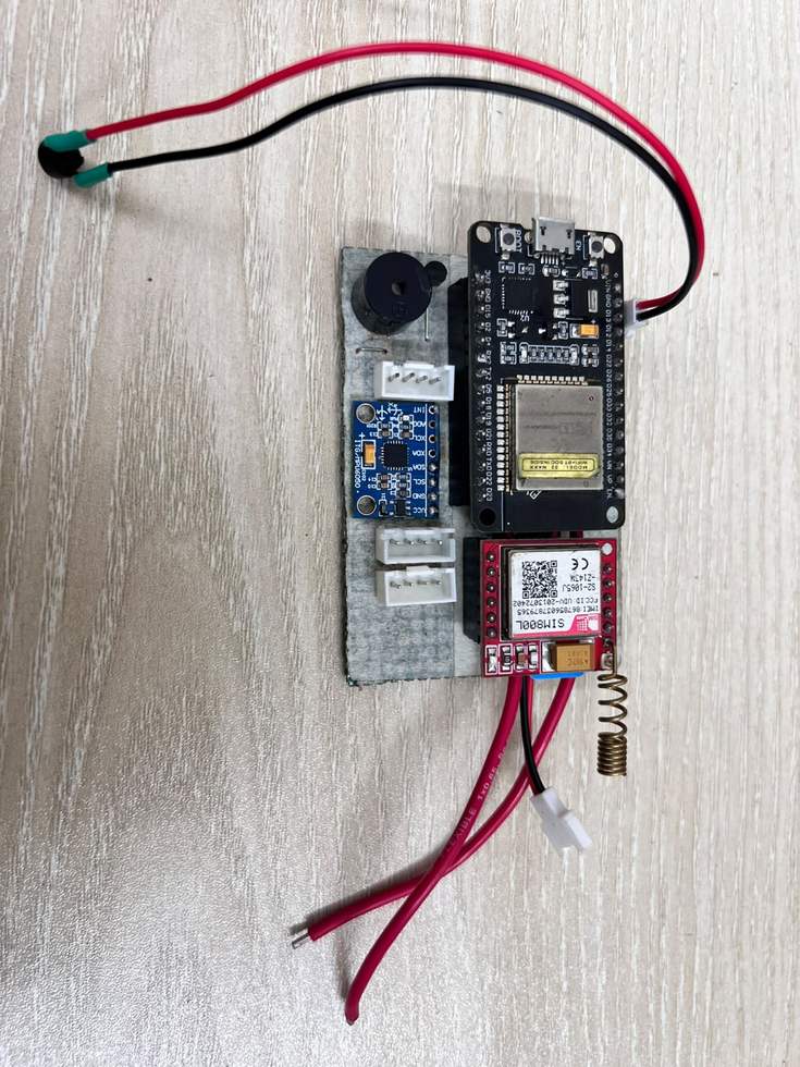 A smaller perfboard carrying a buzzer, a sensor breakout, an ESP32 and a SIM800L module, wired up on its own.